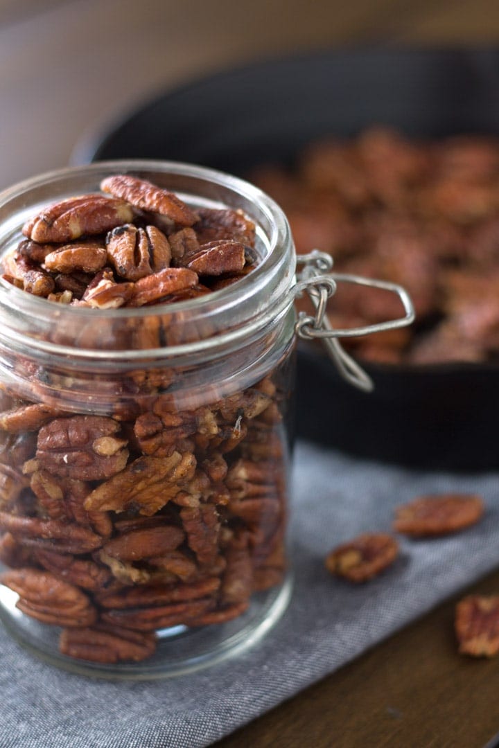 Mapled pecans in jar with pan in background
