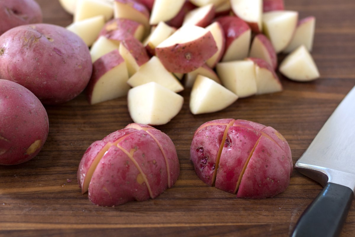 How to cut red skin potato pieces on cutting board.