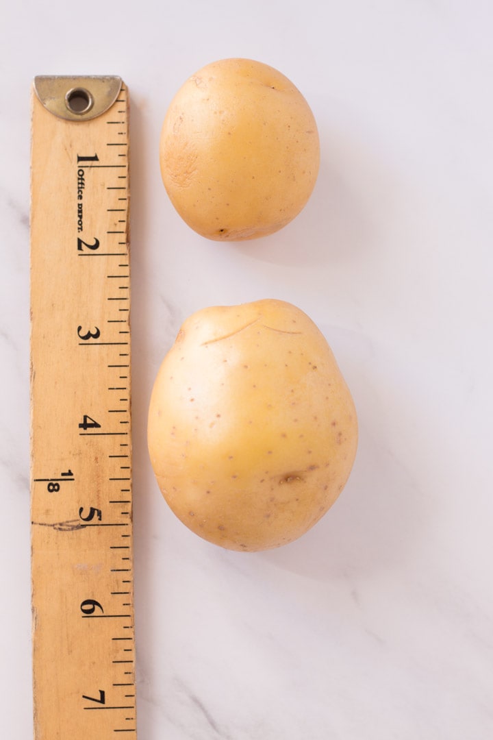 Small potato and medium potato by a ruler