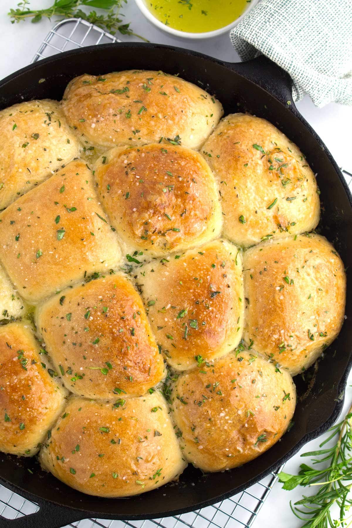 Golden brown Rhodes dinner rolls in a cast iron skillet.