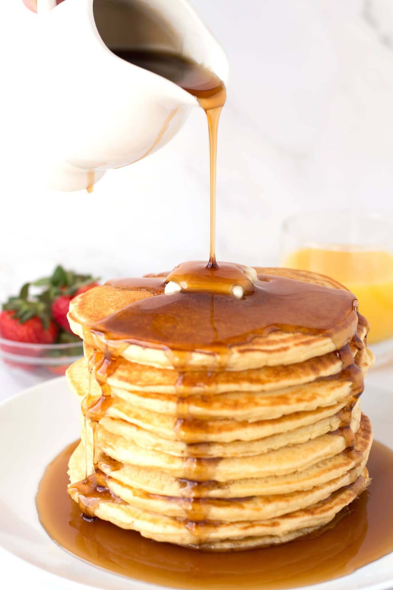 Pouring syrup on Famous Farm Pancakes (with buttermilk)
