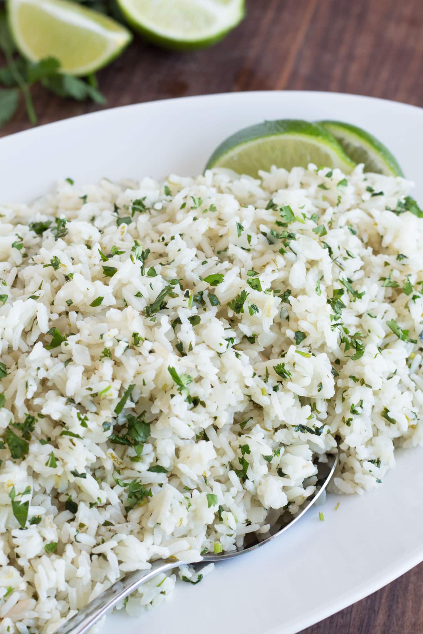 Cilantro lime rice on a platter with a serving spoon.