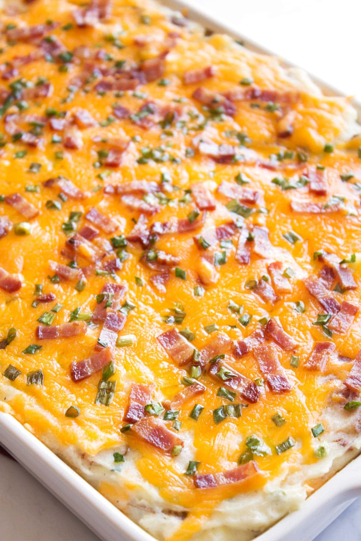 Close view of twice baked potato casserole with plenty of cheese melted on top.