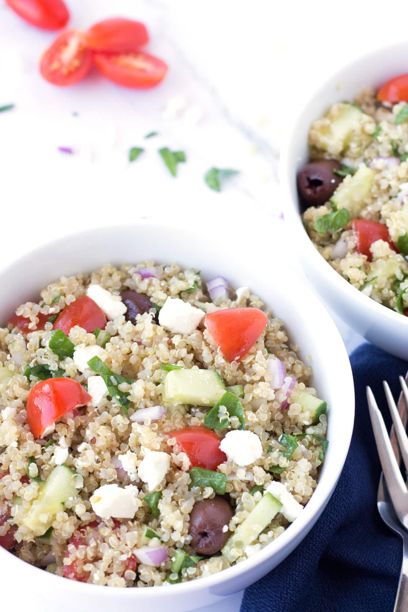 Feta cheese, tomatoes, olives, cucumbers and quinoa in a bowl.