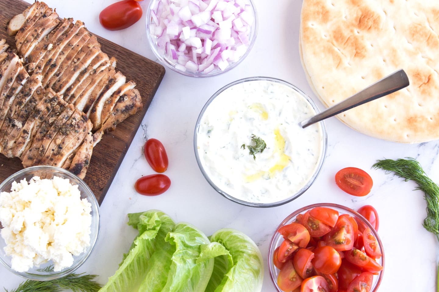 Ingredients for Grilled Greek Chicken Gyros on a countertop.