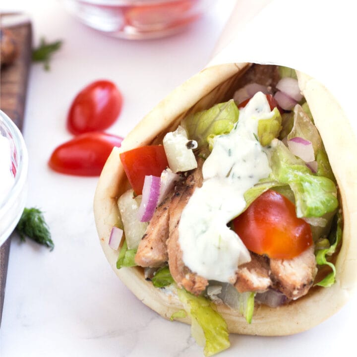 Pita bread around grilled chicken and drizzled with tzatziki sauce.