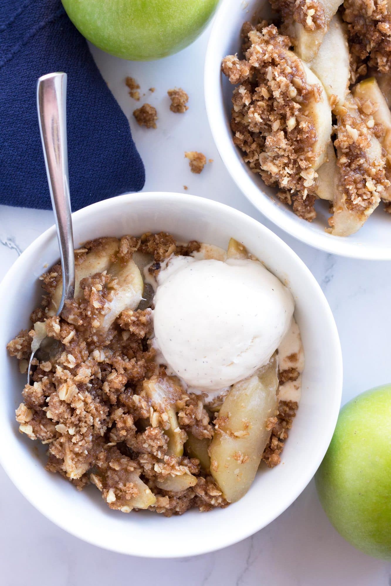 Overhead bowl of apple crisp with scoop of vanilla ice cream