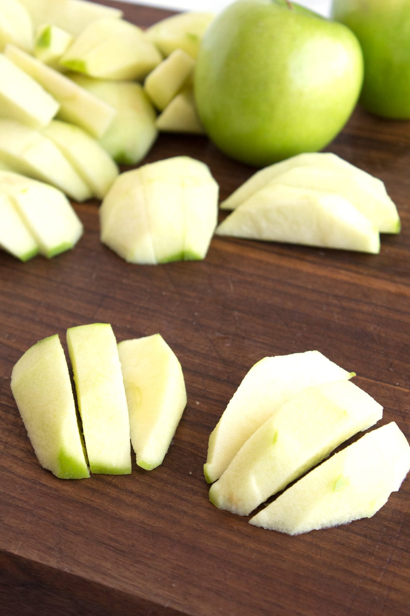 Sliced granny smith apples on cutting board