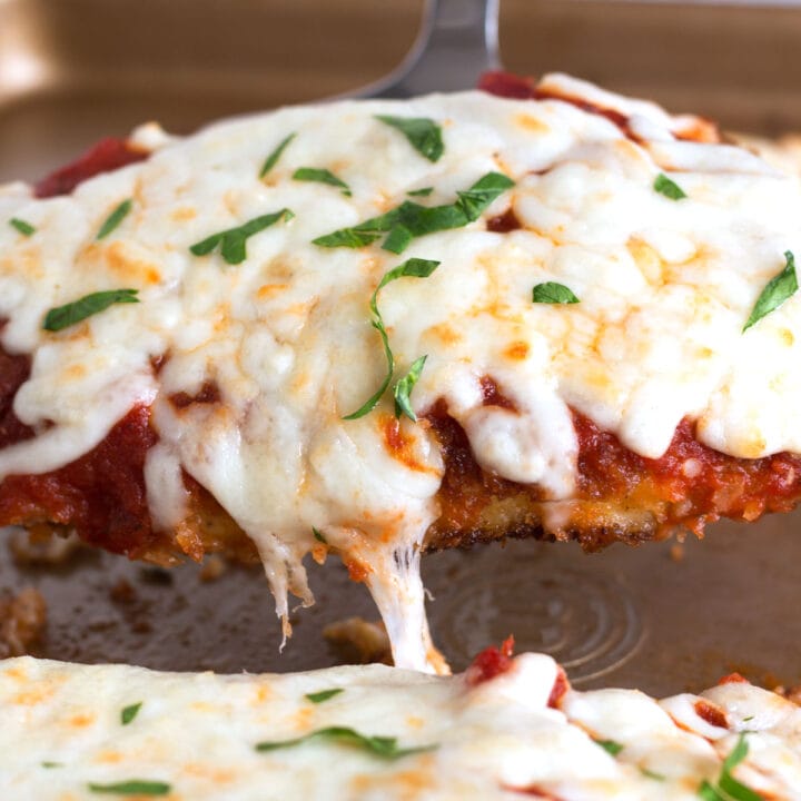 Crispy piece of Chicken Parmesan with melty cheese on top.