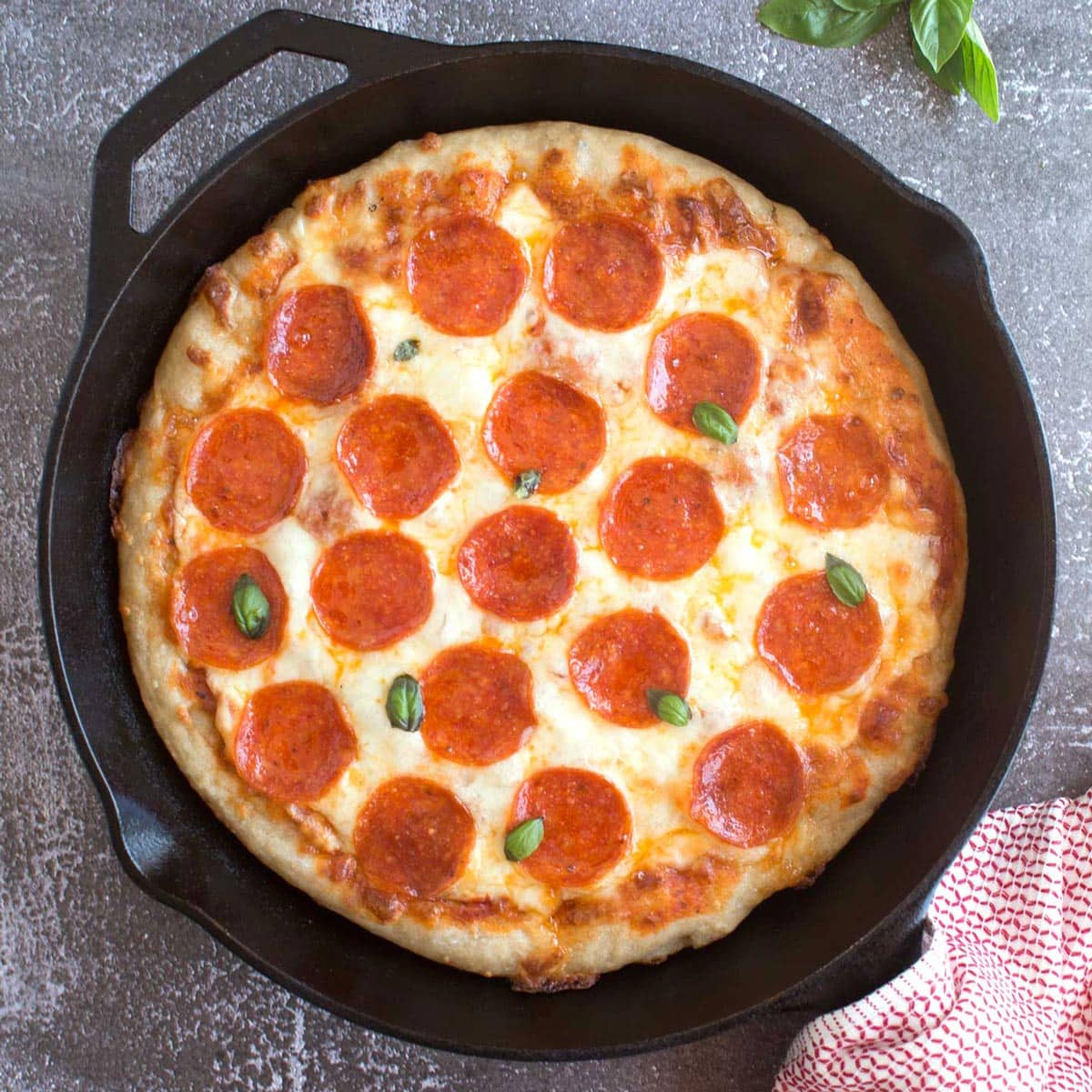 Cast iron skillet with pepperoni and cheese pizza. 