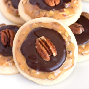 Close view of caramel pecan shortbread cookies stacked on white plate.