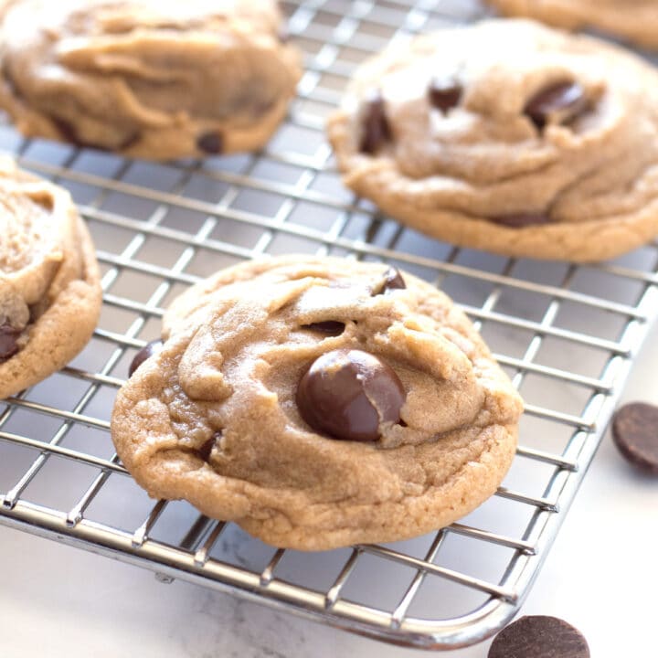 Chocolate chip cookie on cooling rack with more cookies in background