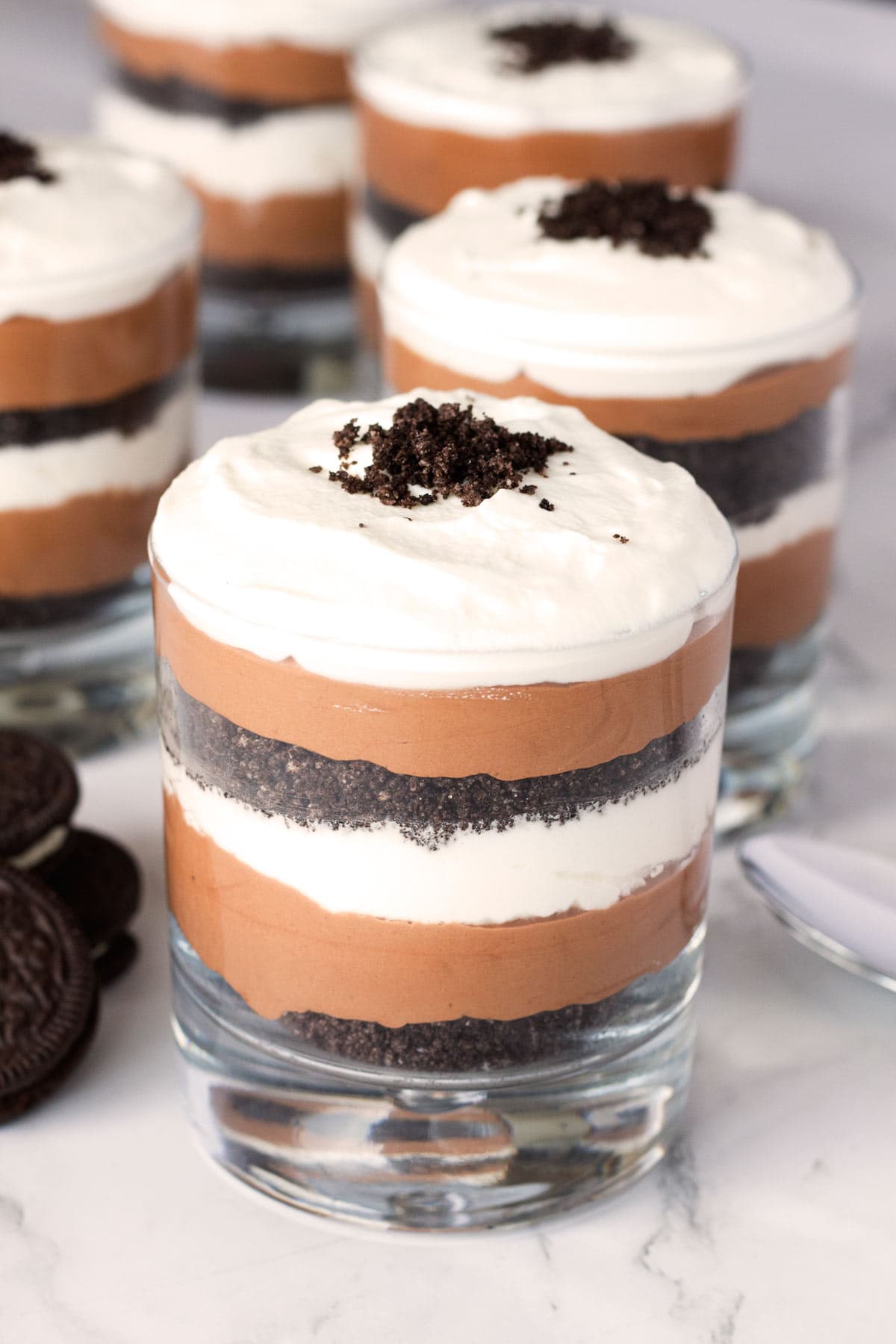 Oreo Cookies next to parfaits filled with chocolate mousse.
