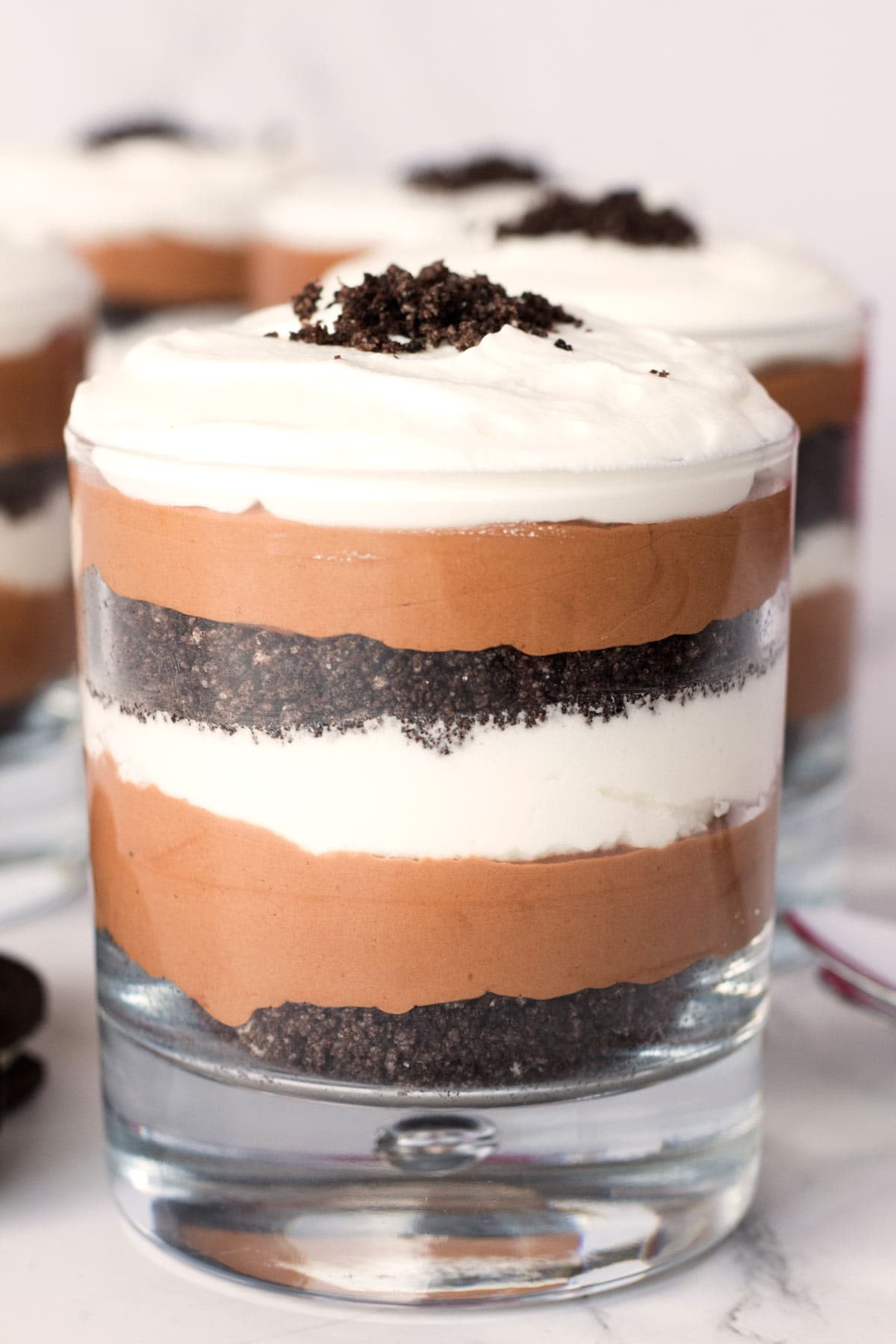 Best chocolate mousse with oreo crumbs and whipped cream layered in a glass cup.