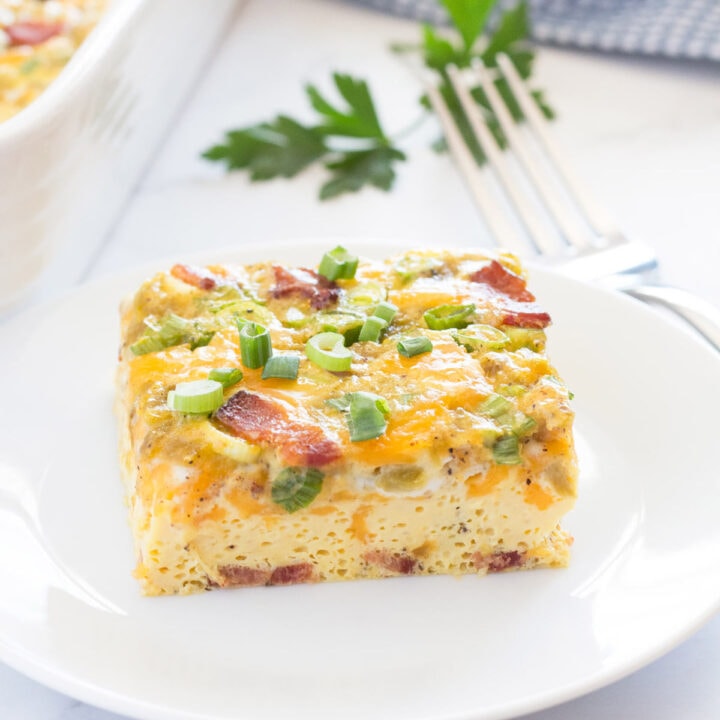 Piece of breakfast casserole with bacon and green chilis on a plate.