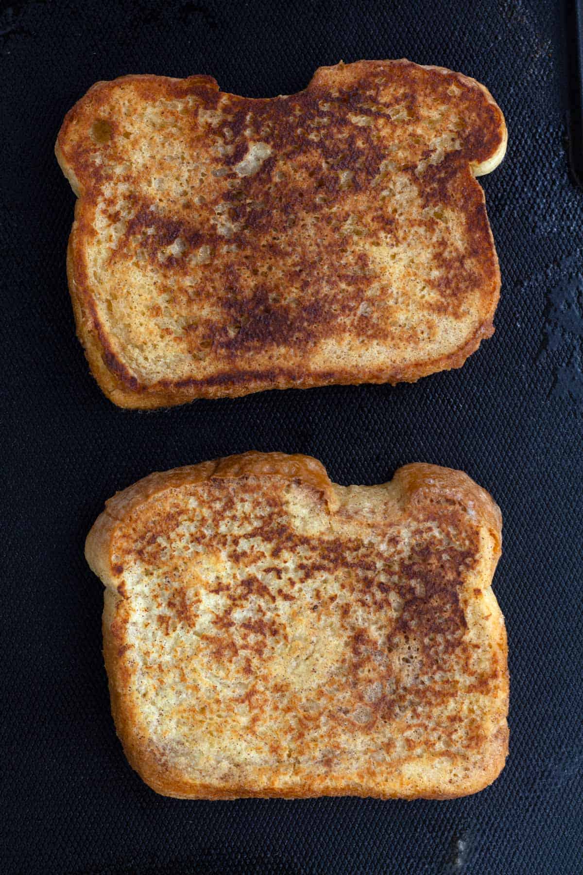 French toast cooking on buttered griddle.