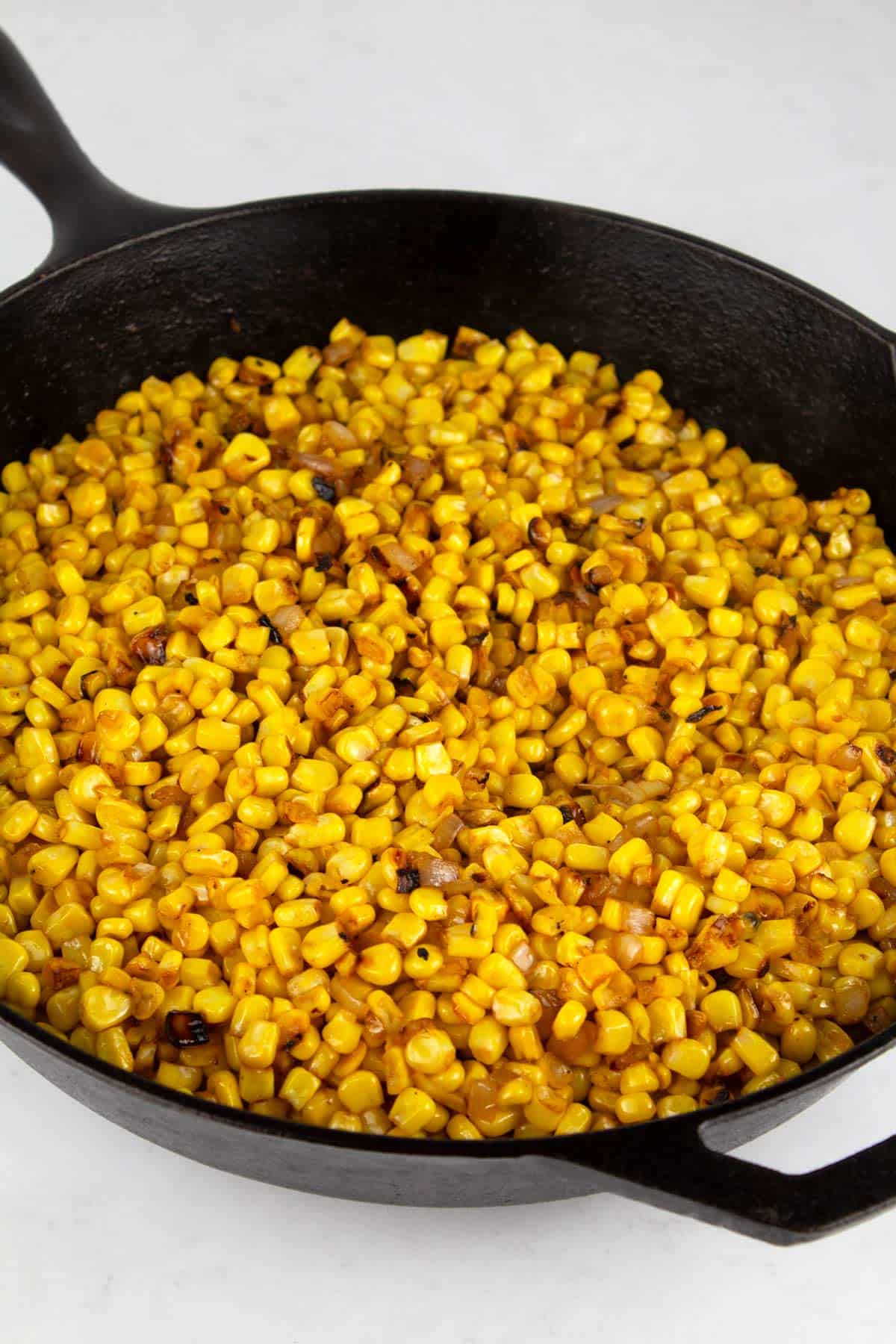 Finished roasted corn in cast iron skillet made with frozen corn.