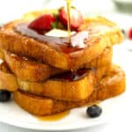 Simple French toast layered on a plate.