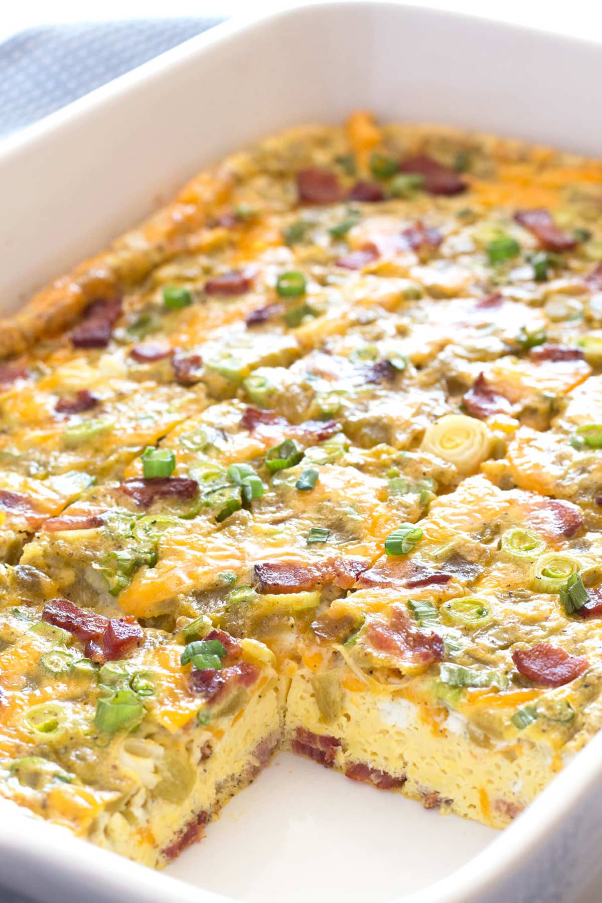 White baking dish with green chili egg bake sliced for Mother's day. 