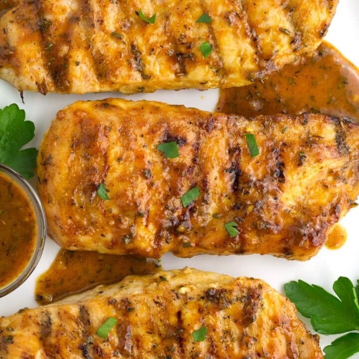 Overhead of chicken breasts on plate with honey mustard sauce drizzled on top.