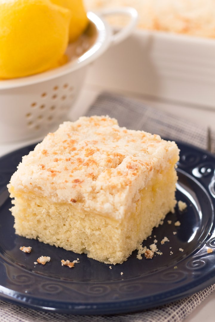 Slice of lemon coffee cake on navy blue plate for brunch. 