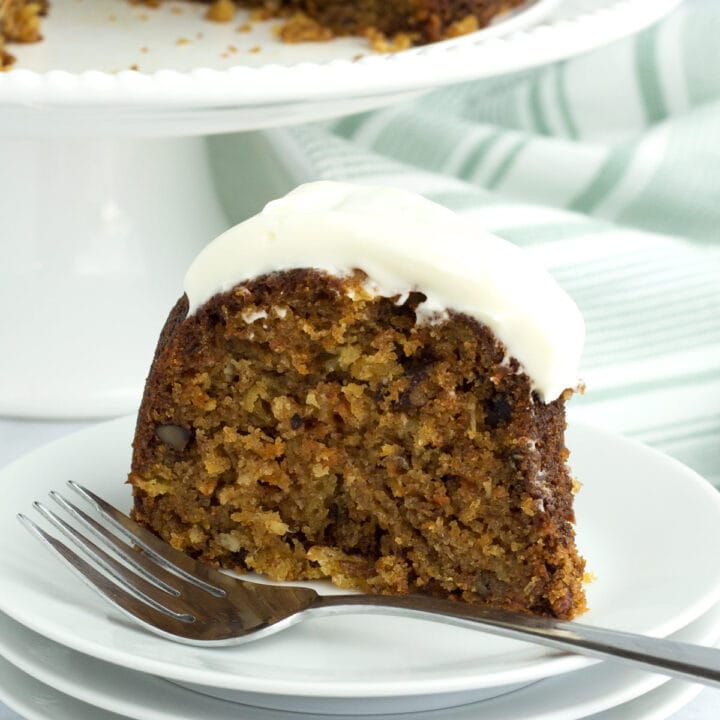 Piece of bundt cake covered with cream cheese frosting on a plate.