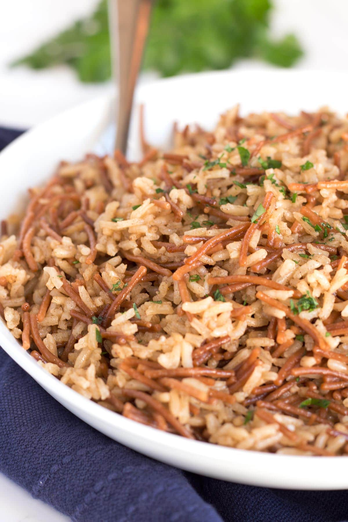 Classic rice pilaf in a bowl with a serving spoon.