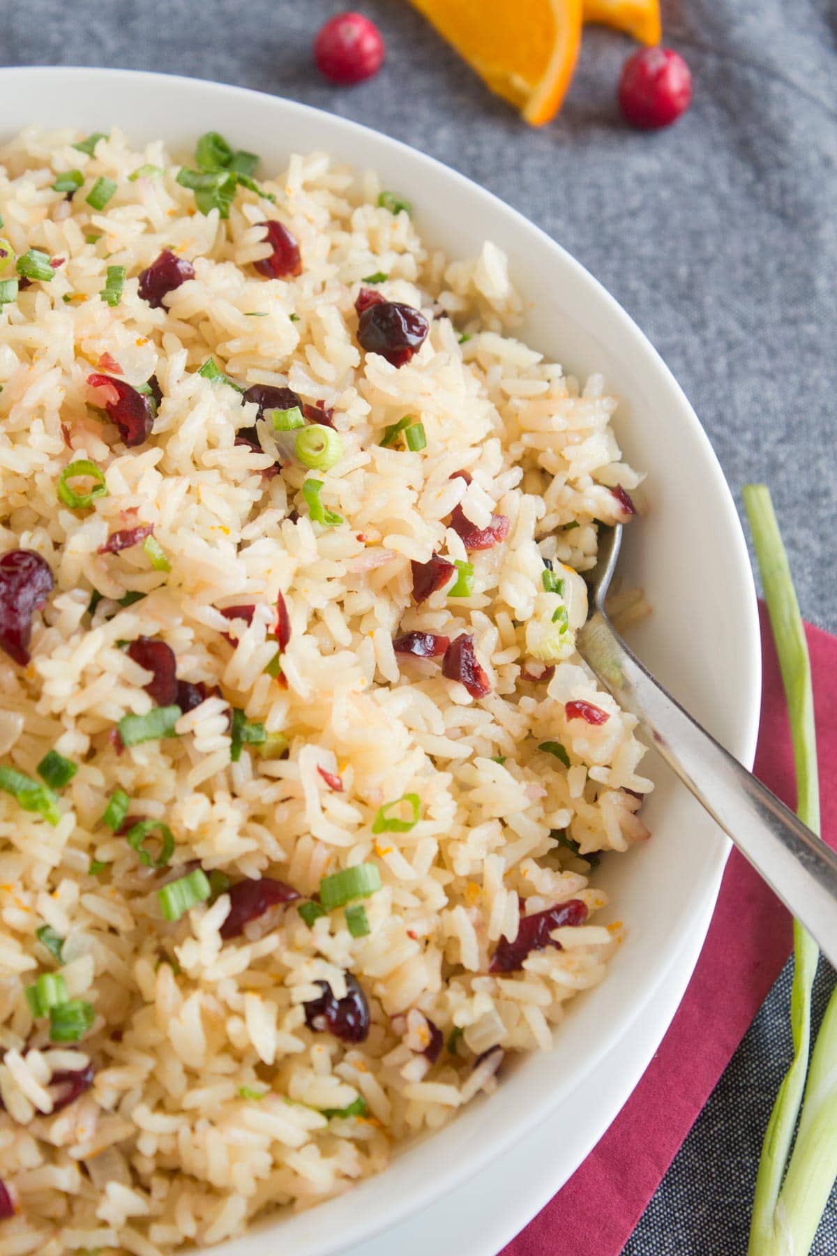 White rice made with orange juice and cranberries in white bowl.