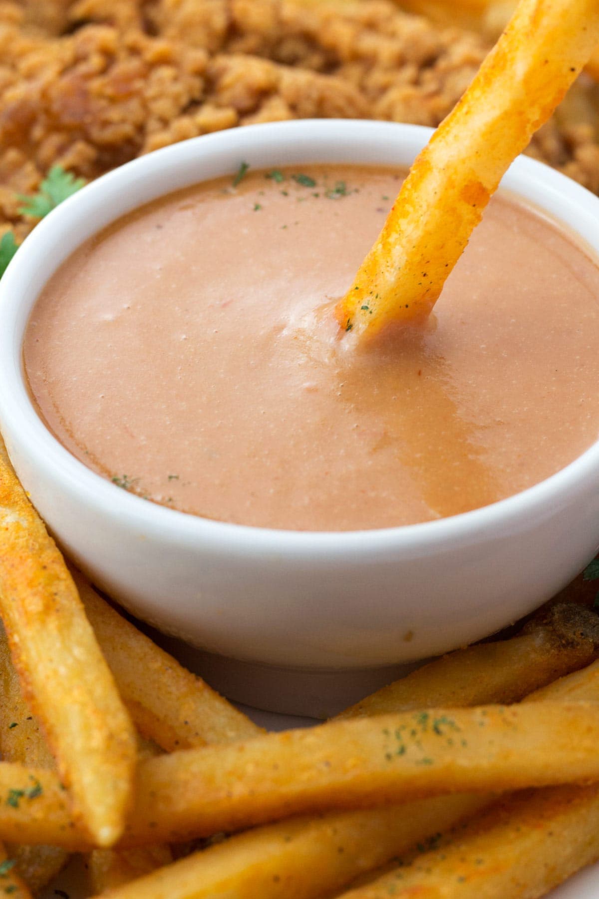 Close view of french fry being dipped into campfire sauce.