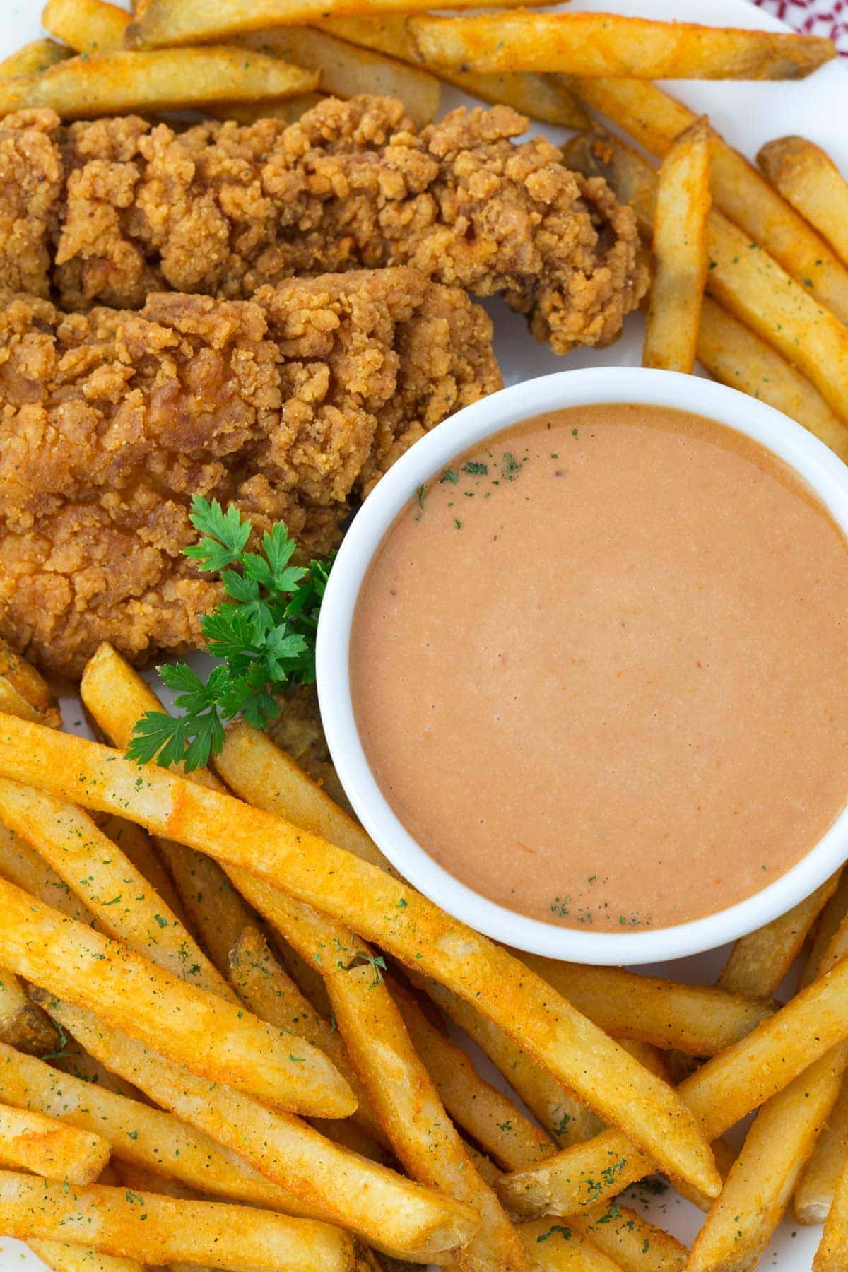Overhead view of platter of french fries and bowl of Red Robin campfire sauce.