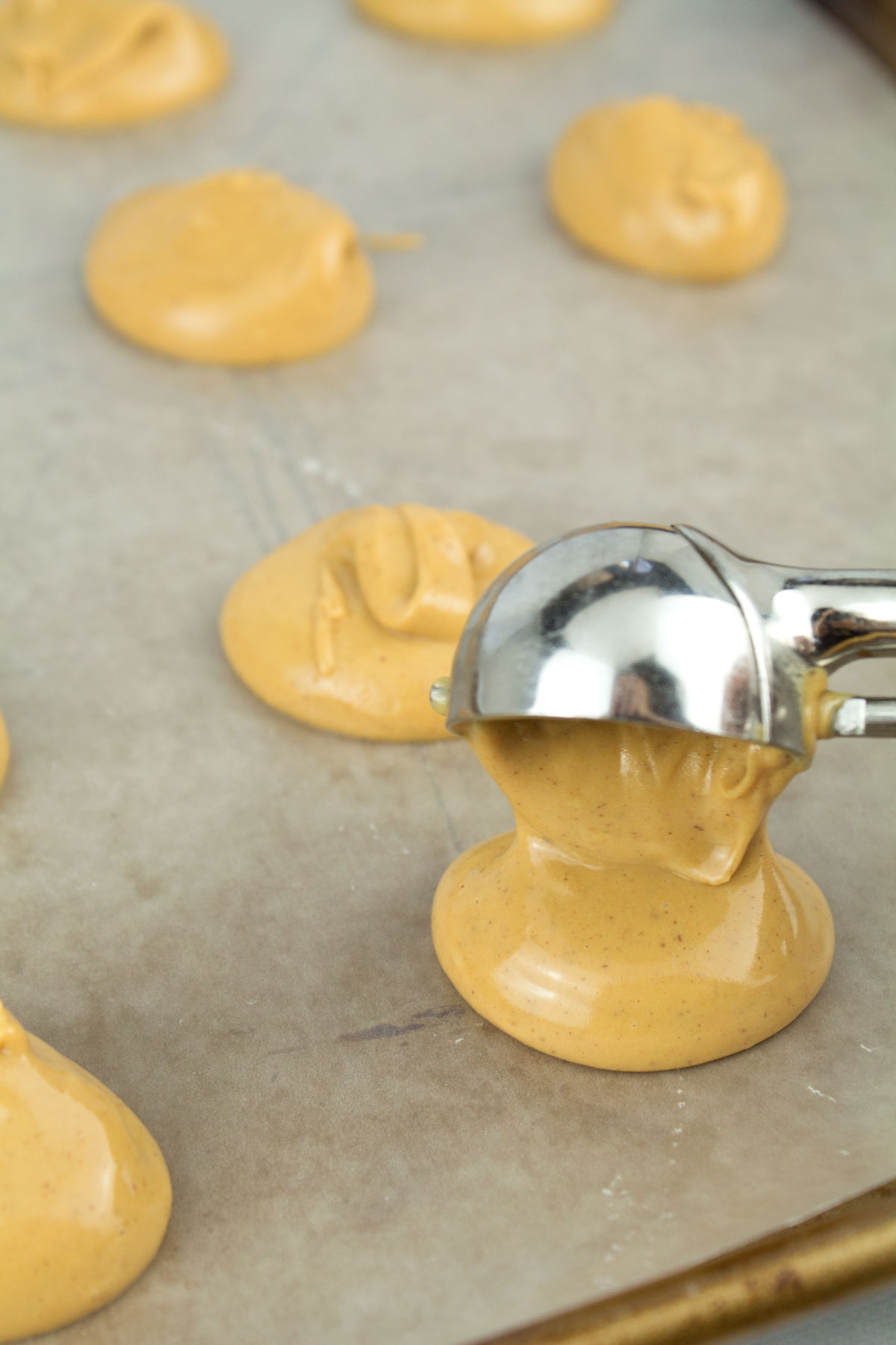 Scooping the filling onto a cookie sheet.
