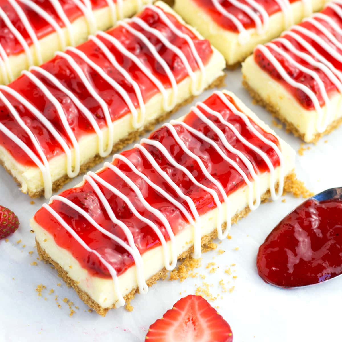 Philadelphia cheesecake bars with strawberry topping on a counter. 