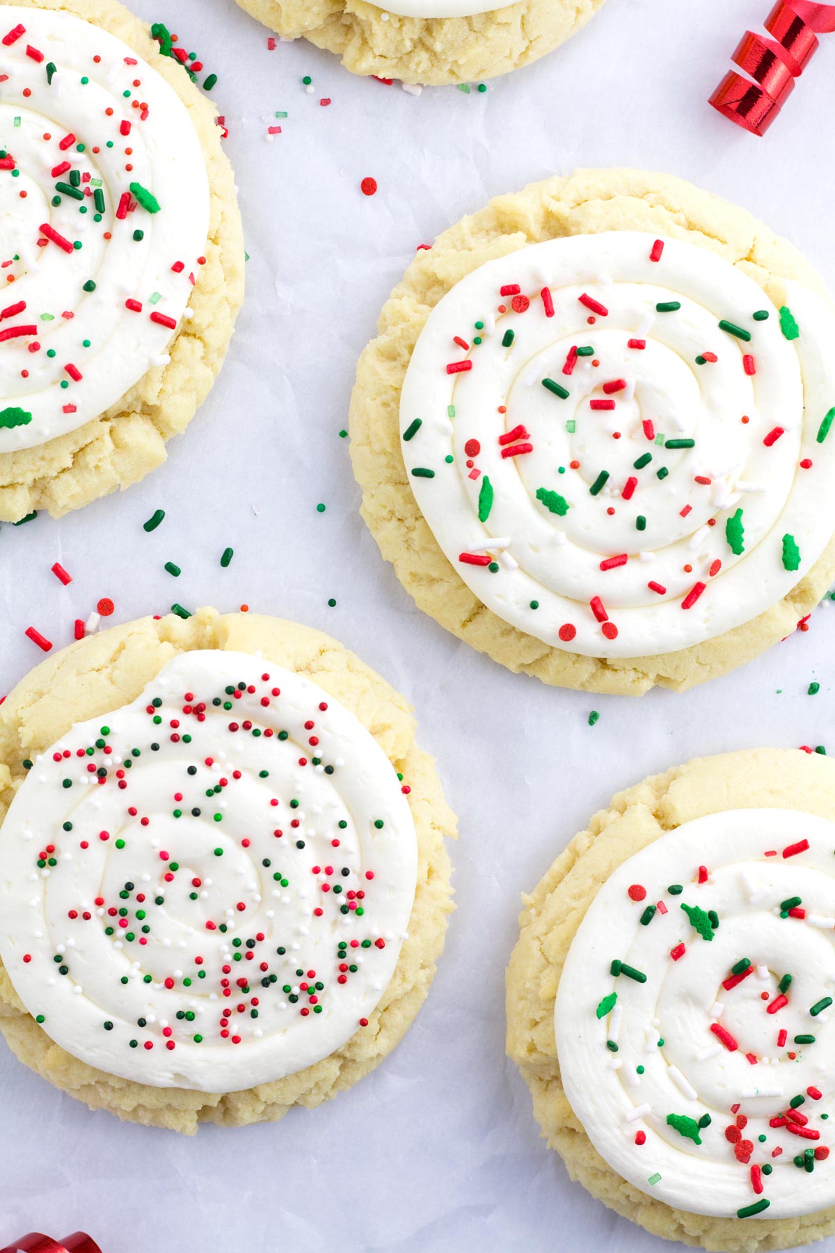 Four staggered Christmas sugar cookies on parchment paper