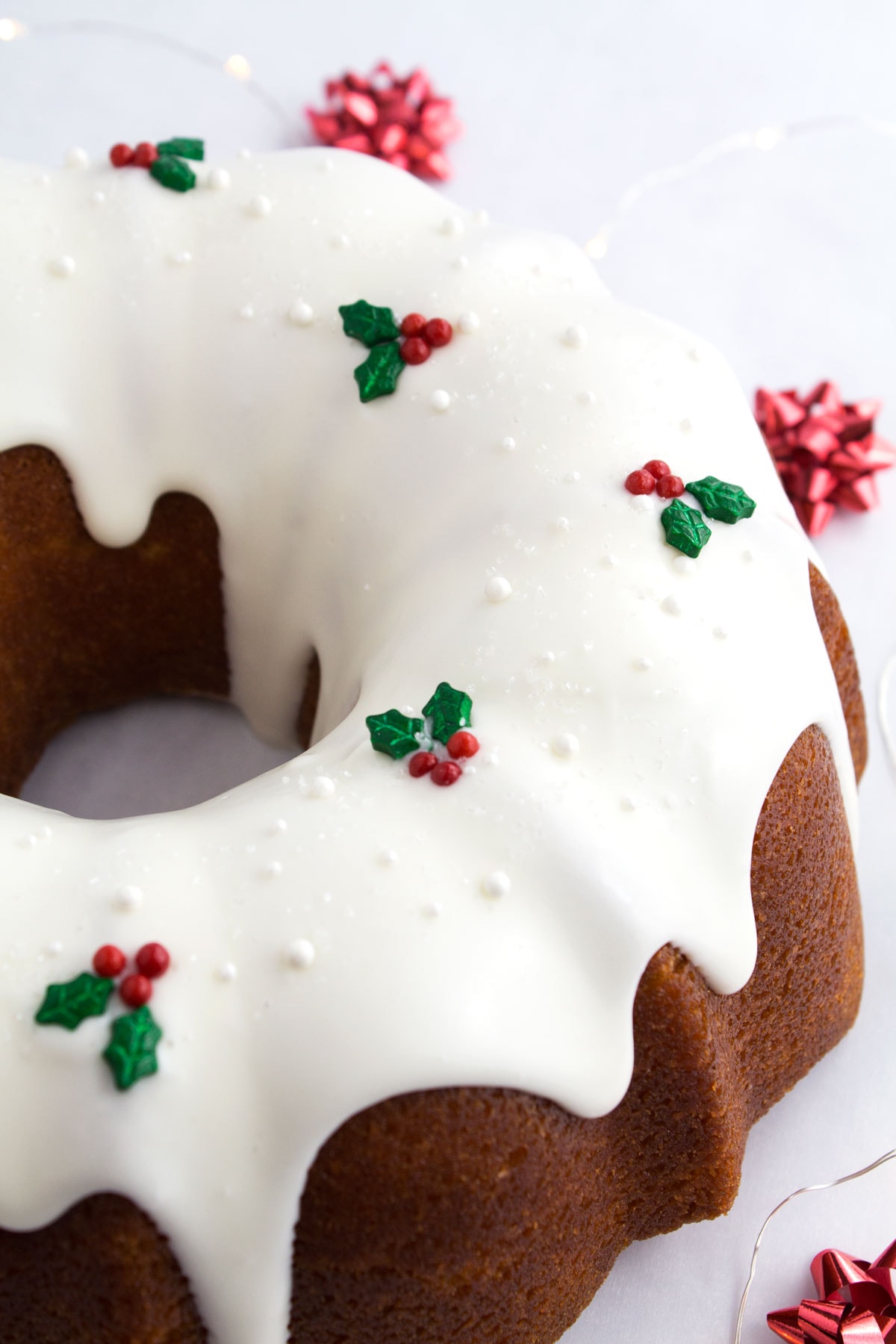 Decorating a Christmas bundt cake with holly and berry sprinkles.