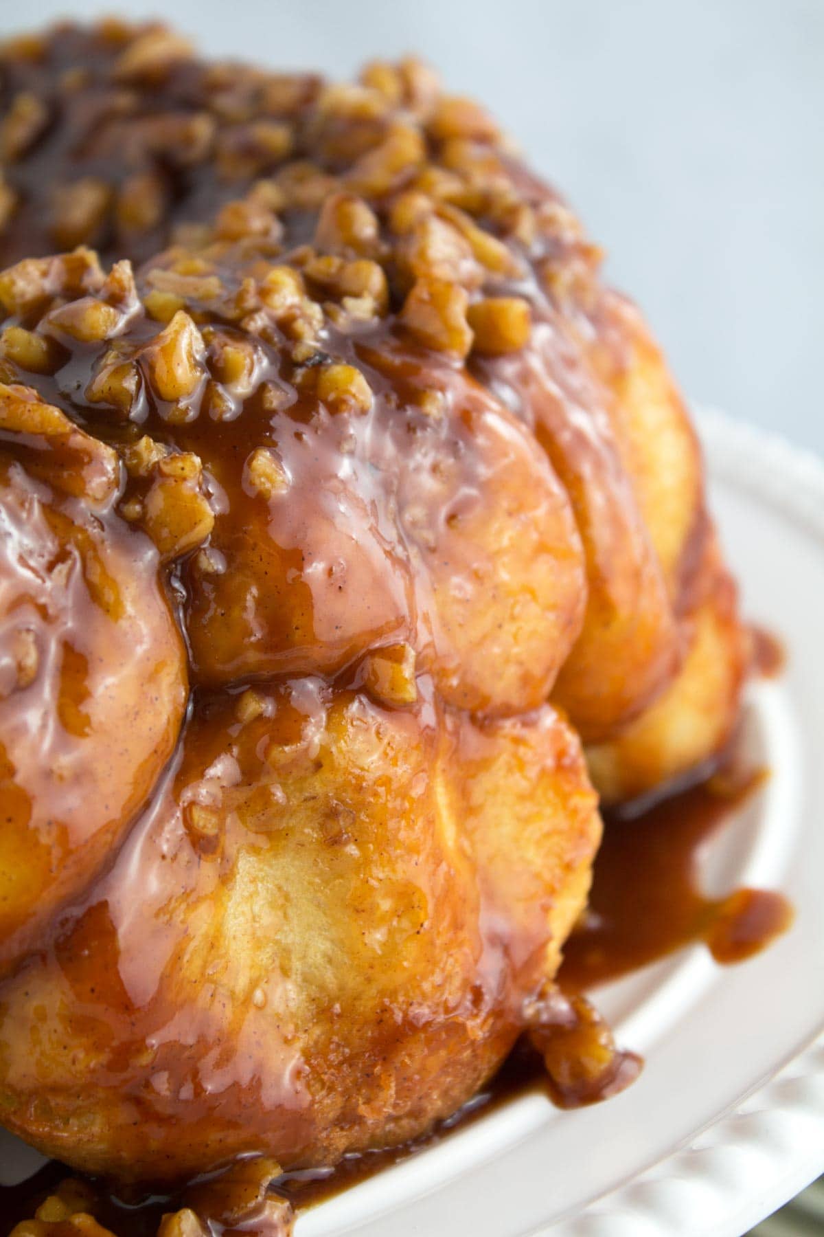 Nuts on top of frozen rolls made into monkey bread with sauce dripping down the side.