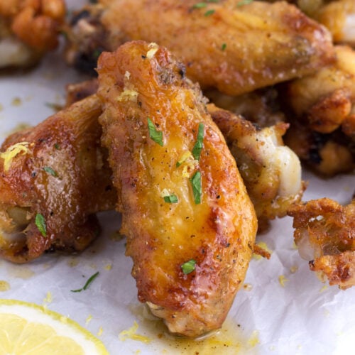 Close up of honey lemon pepper wing with parsley sprinkled on top.