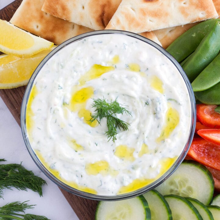 Overhead bowl of Greek yogurt dip surrounded by fresh vegetables.