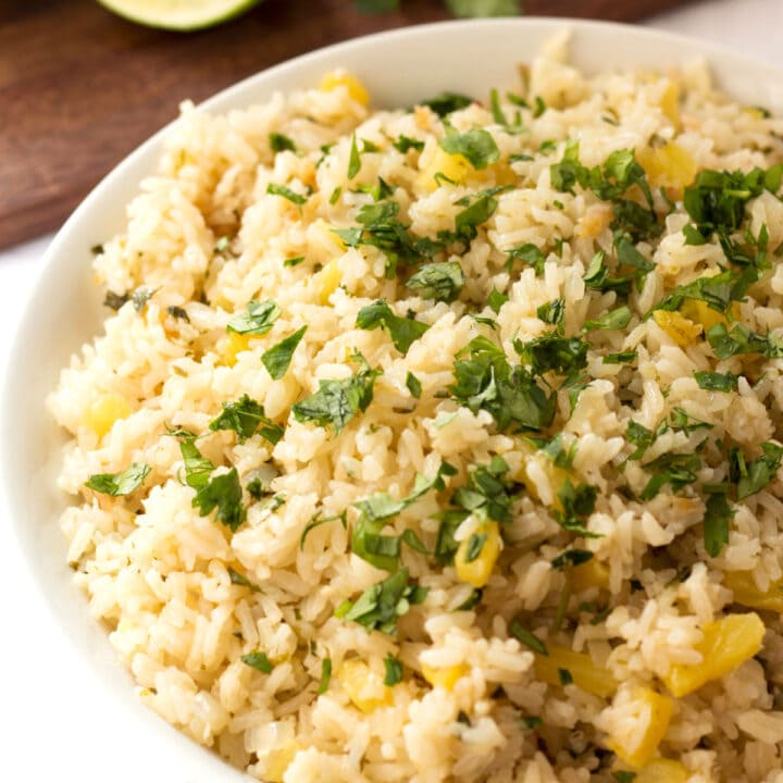 Bowl of pineapple rice with cilantro and lime.