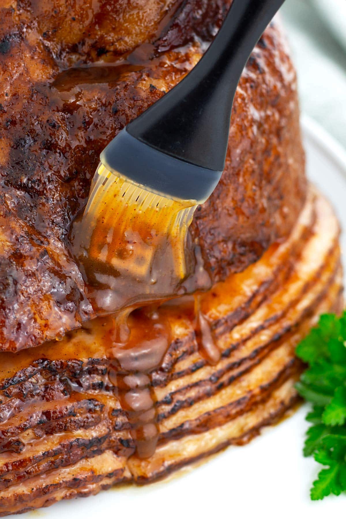 Pastry brushing glaze on ham.