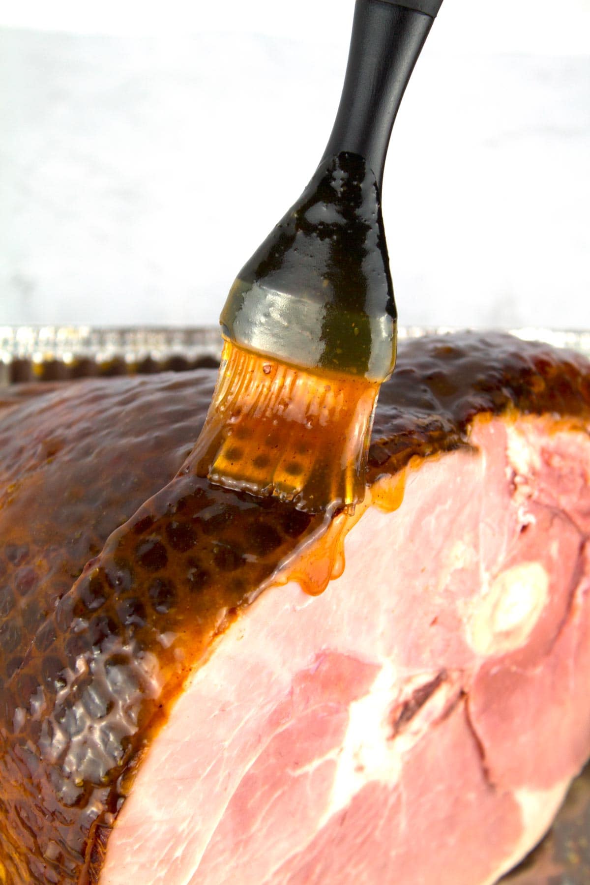 Applying pineapple glaze before baking ham in the electric roaster.