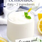 Glass of frosted lemonade with yellow striped straw, blue towels in background, and text overlay.