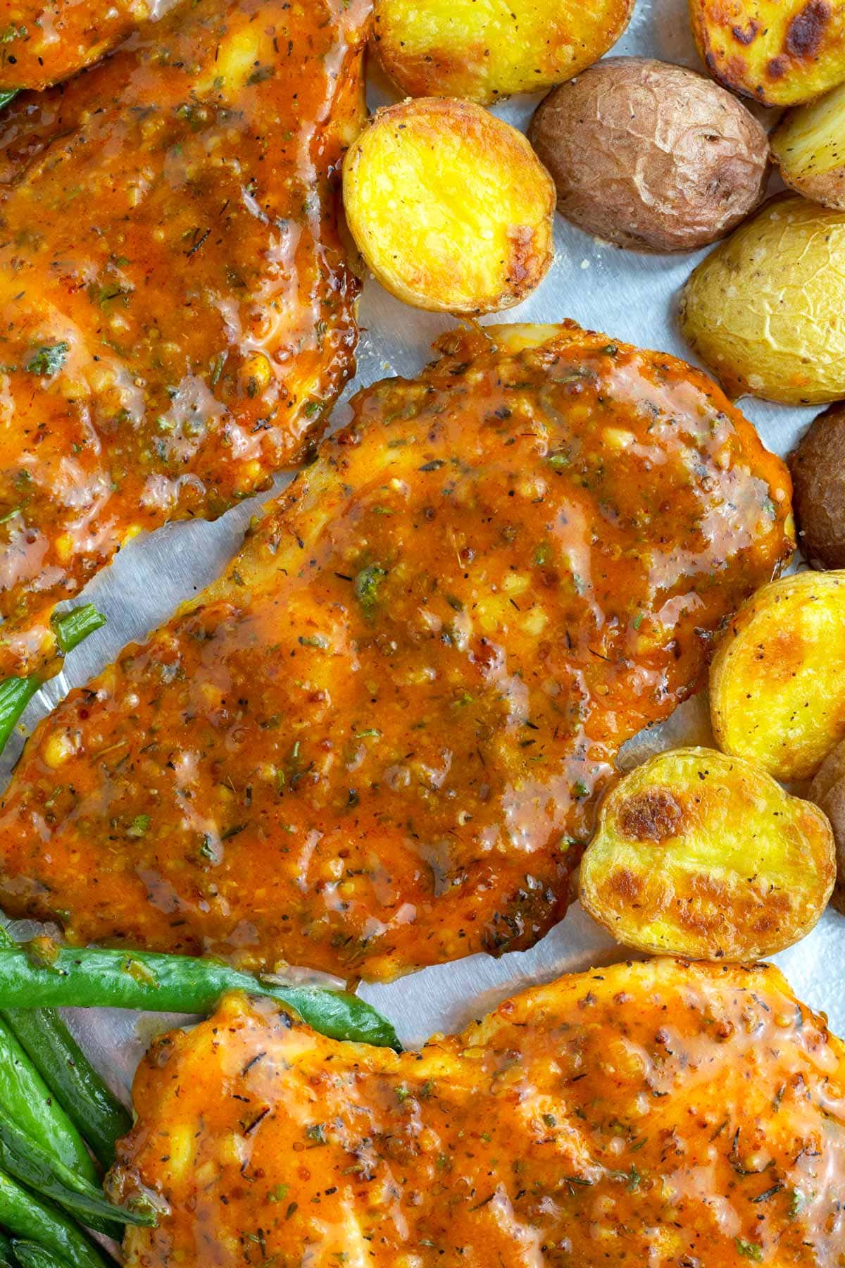 Chicken sheet pan dinner with potatoes and green beans on a foil-lined sheet pan.