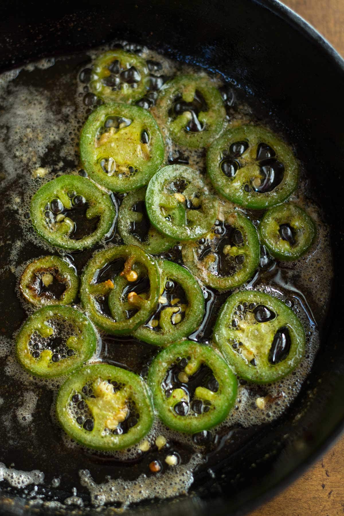 Slices of jalapeno cooking in butter.