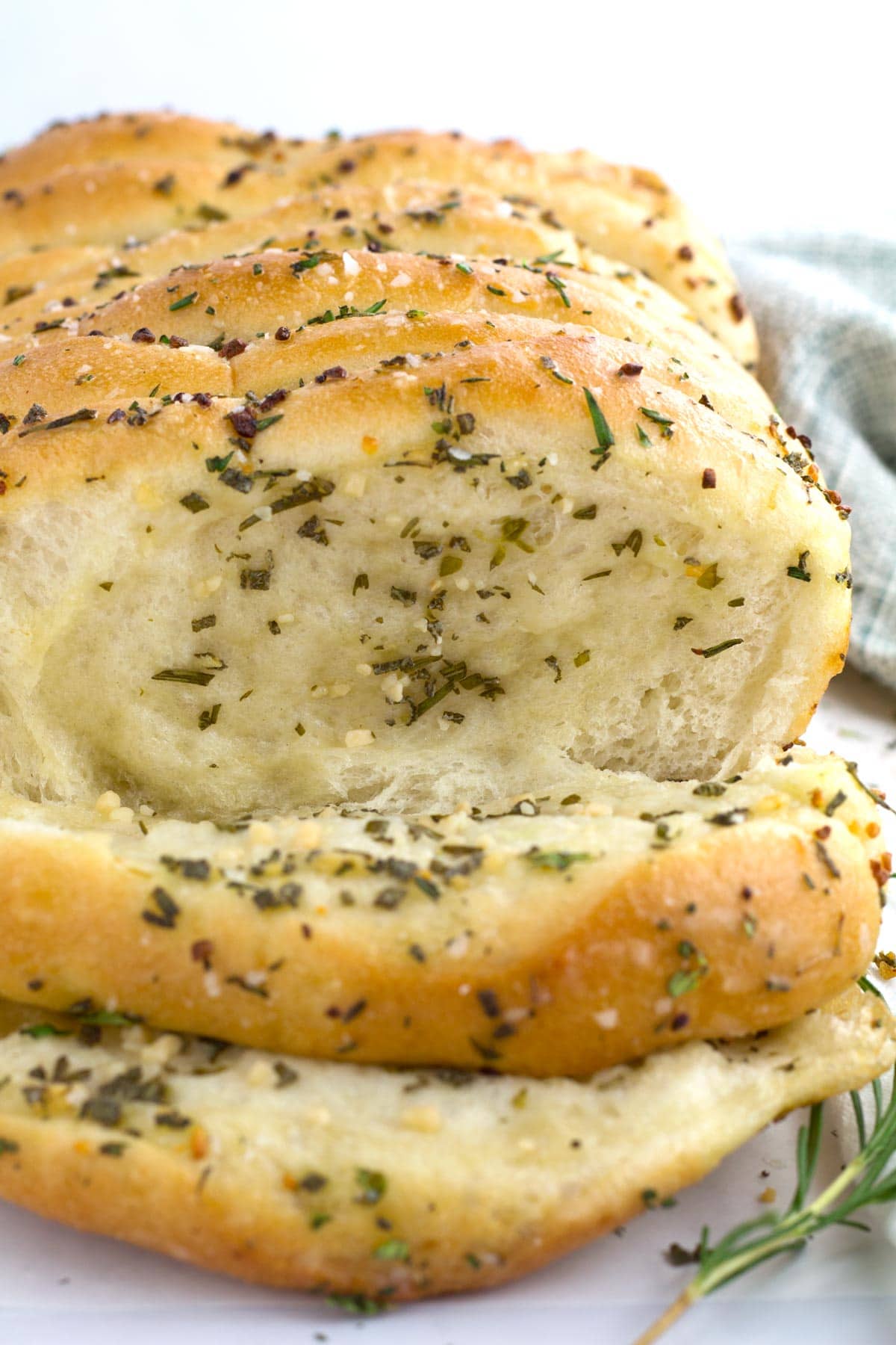 Slices of pull apart bread with garlic and herbs on a countertop.