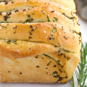 Savory garlic and herb pull apart loaf of bread on countertop.