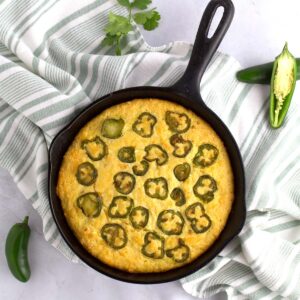 Overhead view of cornbread with jalapenos and cilantro on the counter.