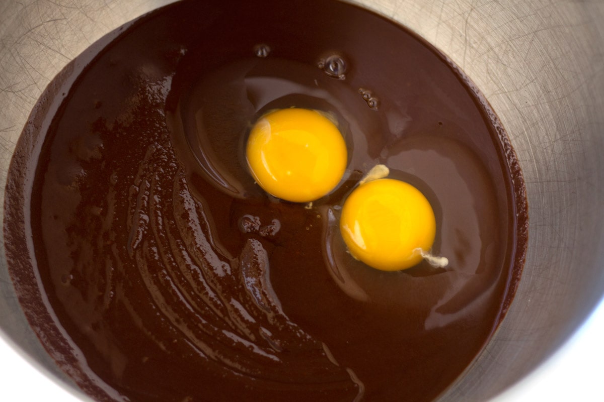 Eggs in bowl of chocolate mixture.