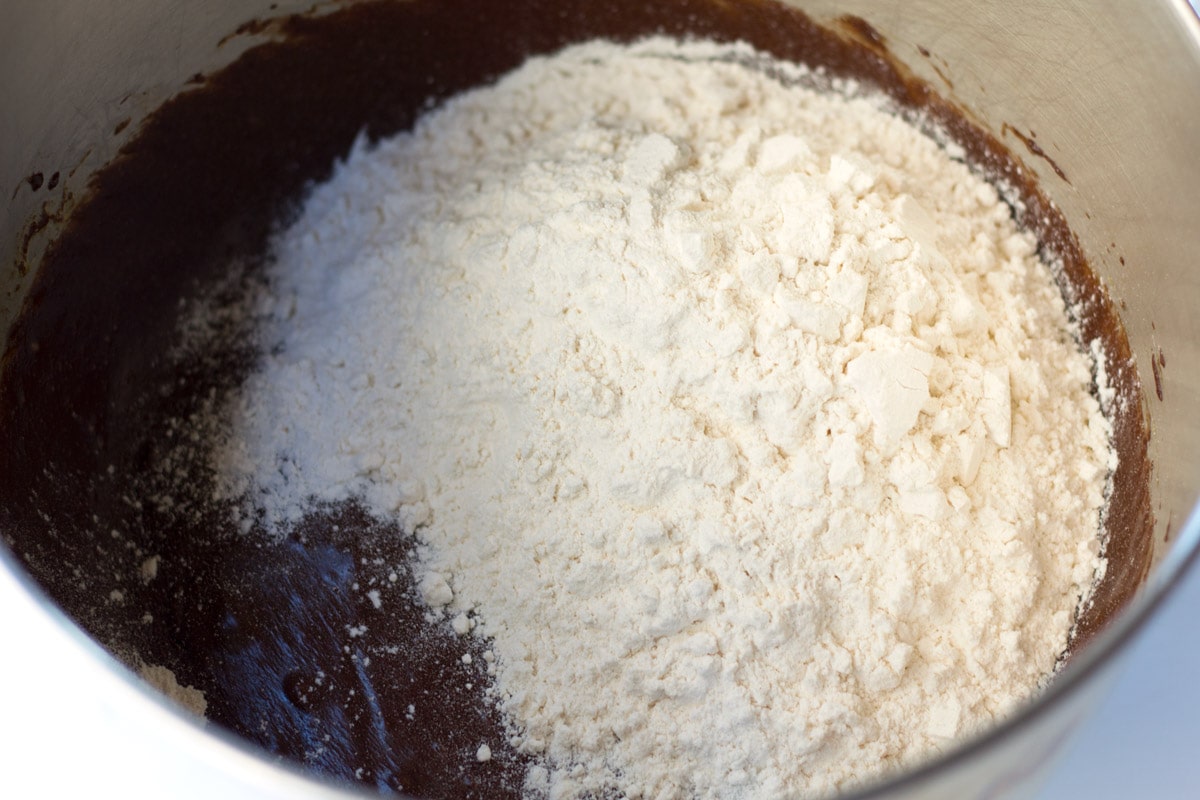 Adding flour into chocolate egg mixture.