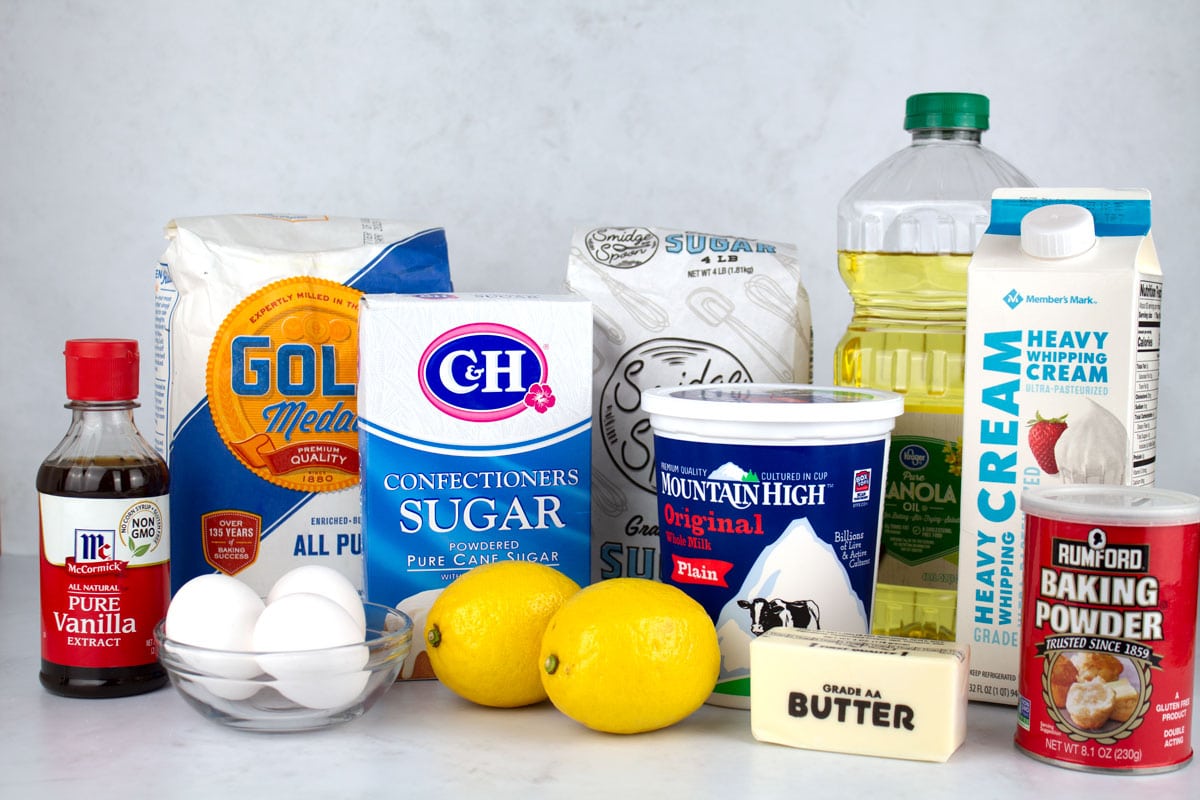Ingredients for lemon cake on a white marble counter.