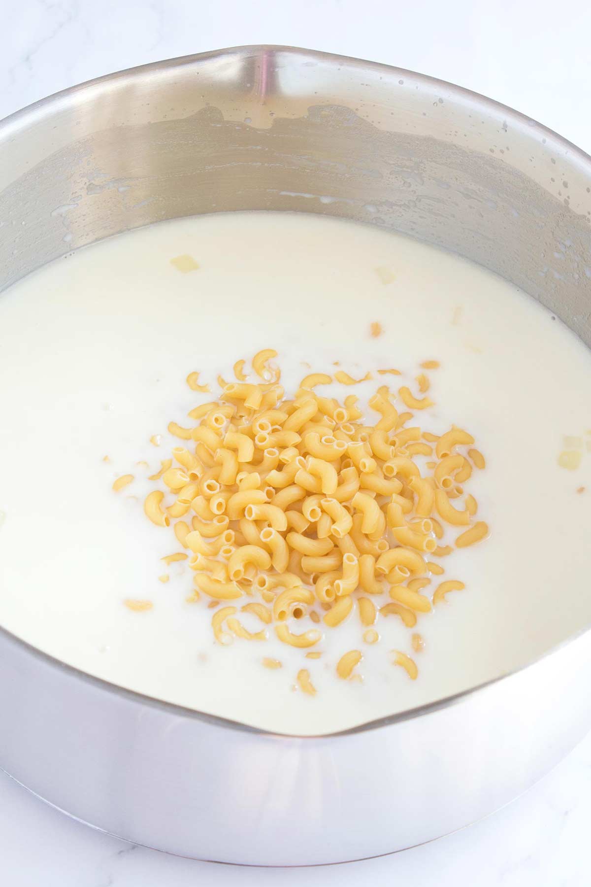 Adding in the macaroni noodles to the milk and chicken broth mixture is the key to keeping this dinner made in only one pot.